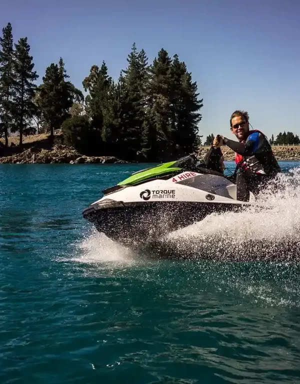 A jet skier enjoying the spray of water and the stunning backdrop of Lalla Takerkoust Lake, near Marrakech, Morocco