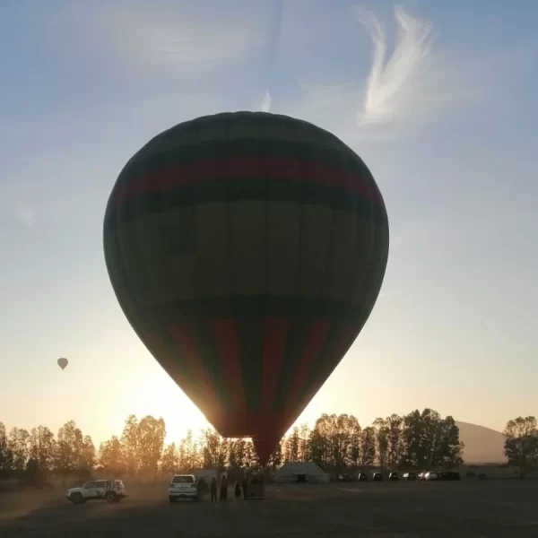 Colorful hot air balloon majestically floating over the mesmerizing landscape of Marrakech Haff-Day Hot Air Balloon Flight , offering a bird's-eye view of the city and its surrounding countryside