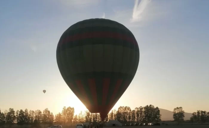 Colorful hot air balloon majestically floating over the mesmerizing landscape of Marrakech Haff-Day Hot Air Balloon Flight , offering a bird's-eye view of the city and its surrounding countryside