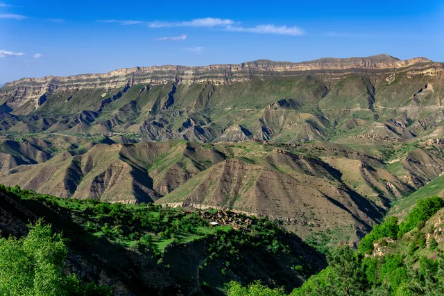 Overview of the Atlas Mountains A panoramic view of the majestic Atlas Mountains Treks, showcasing rugged peaks and lush valleys under a clear blue sky.