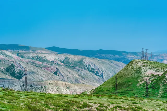 Lush greenery of the Atlas Mountains, showcasing vibrant landscapes and rolling hills under a clear blue sky.